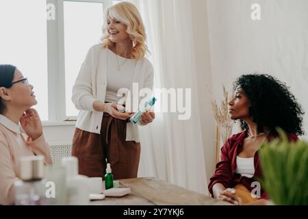 Tre donne mature che sorridono mentre esaminano insieme i prodotti di bellezza Foto Stock