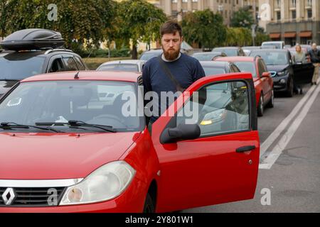 KIEV, UCRAINA - 1 SETTEMBRE 2024 - Un autista sta accanto alla sua auto durante un minuto di silenzio a livello nazionale in memoria dei soldati caduti nel giorno dei difensori dell'Ucraina, in piazza Maidan Nezalezhnosti, Kiev, capitale dell'Ucraina Foto Stock