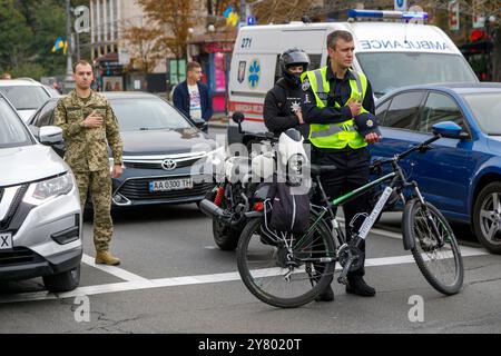 KIEV, UCRAINA - 1 SETTEMBRE 2024 - Un poliziotto con una bicicletta e i piloti su strada partecipano a un minuto di silenzio nazionale in memoria dei soldati morti nel giorno dei difensori dell'Ucraina, in piazza Maidan Nezalezhnosti, Kiev, capitale dell'Ucraina Foto Stock