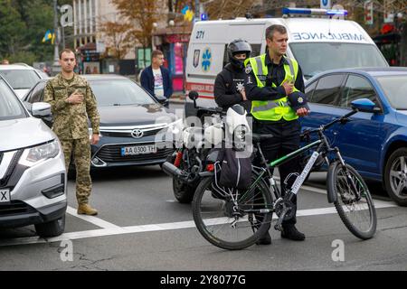 Non esclusiva: KIEV, UCRAINA - 1 SETTEMBRE 2024 - Un poliziotto con una bicicletta e i conducenti su strada partecipano a un minuto di silenzio a livello nazionale Foto Stock