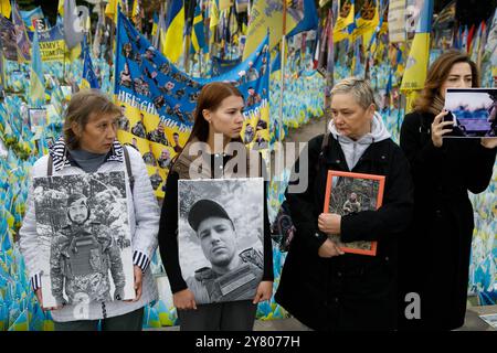 Non esclusiva: KIEV, UCRAINA - 01 SETTEMBRE 2024 - le persone tengono cartelli presso il "prato della memoria nazionale" coperto di bandiere con i nomi di caduto He Foto Stock