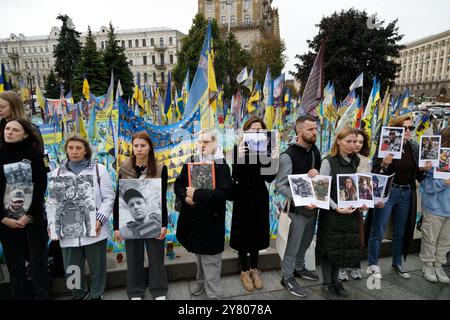 Non esclusiva: KIEV, UCRAINA - 01 SETTEMBRE 2024 - le persone tengono cartelli presso il "prato della memoria nazionale" coperto di bandiere con i nomi di caduto He Foto Stock