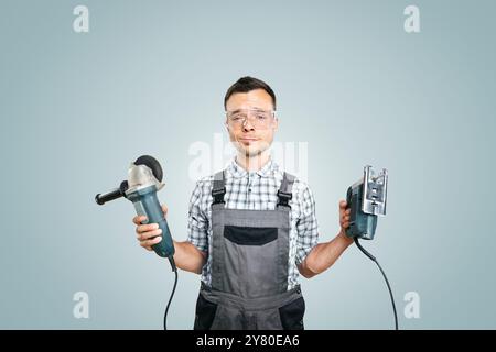 Ritratto di un lavoratore che tiene gli utensili elettrici in entrambe le mani Foto Stock