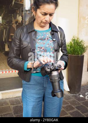 Mantova, Italia 30 settembre 2024 turista in piedi nel centro storico di mantova, italia, e guardando le foto appena scattate con la sua macchina fotografica Foto Stock