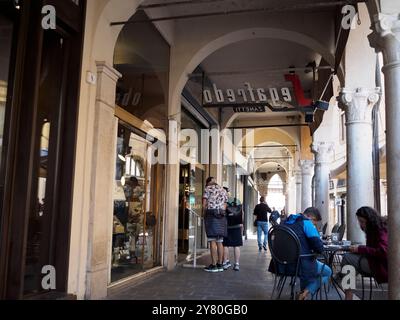 Mantova, Italia 30 settembre 2024 persone passeggiando e sedute ai tavoli di caffetterie all'aperto sotto gli archi del centro storico di mantova, lombardia, Foto Stock