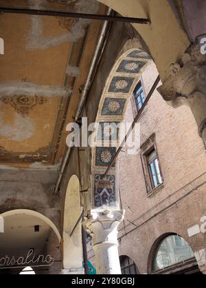 Mantova, Italia 30 settembre 2024 dettaglio architettonico di una galleria affrescata con colonna in marmo, nel centro storico di mantova Foto Stock