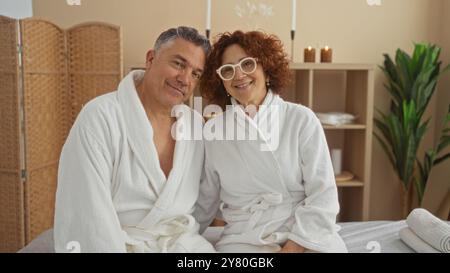 Coppia di mezza età che si rilassa in una spa, indossa accappatoi in un centro benessere sereno, che rappresenta amore e tranquillità. Foto Stock