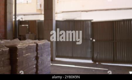 Sito di costruzione sfocato con edifici non finiti e materiali impilati su sfondo bokeh Foto Stock