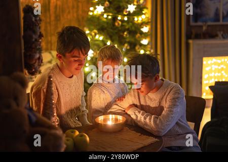 Dolci bambini, simpatici ragazzi, fratelli, giocare con i giocattoli di natale a Natale, accendere le candele in poche parole, tradizioni natalizie ceche luogo accogliente W Foto Stock