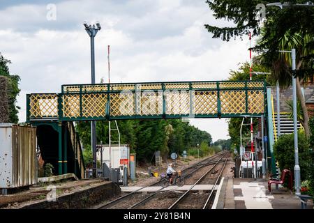 Ciclista su un passaggio a livello ferroviario Foto Stock