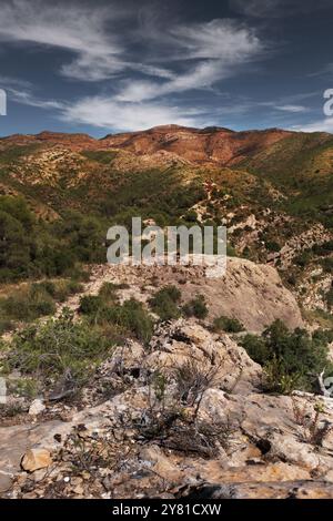 Paesaggio del sentiero roccioso sulla scogliera che si affaccia sulla lussureggiante Green Valley con ampia vista del cielo Foto Stock