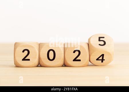 Blocchi in legno con numeri variabili da 2024 a 2025. Concetto di anno nuovo. Copia spazio. Sfondo bianco Foto Stock