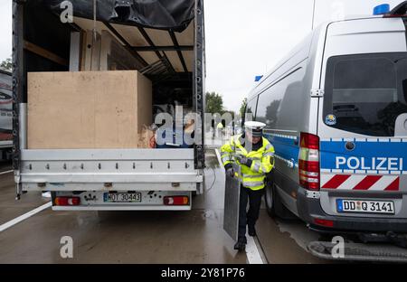 Chemnitz, Germania. 2 ottobre 2024. Un agente di polizia utilizza bilance mobili per controllare un furgone nell'area di riposo "Auerswalder Blick" sulla superstrada A4 vicino a Chemnitz come parte di una giornata nazionale di ricerca e controllo. Il giorno della caccia all'uomo, i posti di blocco erano presidiati nelle rispettive aree di responsabilità delle stazioni di polizia del dipartimento di polizia di Chemnitz e sulla A4. I controlli mobili sono stati effettuati contemporaneamente. Il supporto è stato fornito dalla polizia federale e dagli agenti doganali. Crediti: Hendrik Schmidt/dpa/Alamy Live News Foto Stock