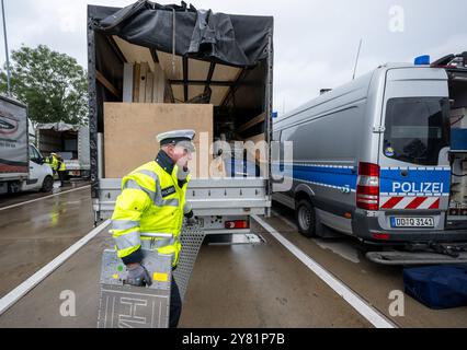 Chemnitz, Germania. 2 ottobre 2024. Un agente di polizia utilizza bilance mobili per controllare un furgone nell'area di riposo "Auerswalder Blick" sulla superstrada A4 vicino a Chemnitz come parte di una giornata nazionale di ricerca e controllo. Il giorno della caccia all'uomo, i posti di blocco erano presidiati nelle rispettive aree di responsabilità delle stazioni di polizia del dipartimento di polizia di Chemnitz e sulla A4. I controlli mobili sono stati effettuati contemporaneamente. Il supporto è stato fornito dalla polizia federale e dagli agenti doganali. Crediti: Hendrik Schmidt/dpa/Alamy Live News Foto Stock