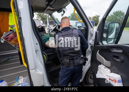 Chemnitz, Germania. 2 ottobre 2024. Un funzionario doganale perquisisce un furgone nell'area di riposo "Auerswalder Blick" sull'Autobahn 4 vicino a Chemnitz come parte di una giornata nazionale di ricerca e controllo. Il giorno della ricerca, i posti di blocco erano presidiati nelle rispettive aree di responsabilità delle stazioni di polizia del dipartimento di polizia di Chemnitz e sulla A4. I controlli mobili sono stati effettuati contemporaneamente. Il supporto è stato fornito dalla polizia federale e dagli agenti doganali. Crediti: Hendrik Schmidt/dpa/Alamy Live News Foto Stock