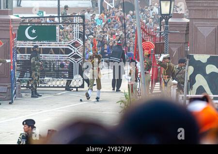 Le forze di sicurezza di frontiera sfilano durante la cerimonia di abbassamento della bandiera del confine Attari-Wagah Foto Stock