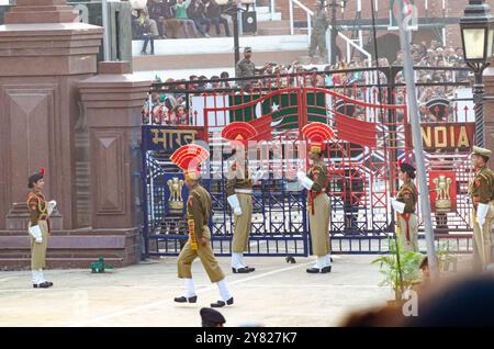 Le forze di sicurezza di frontiera sfilano durante la cerimonia di abbassamento della bandiera del confine Attari-Wagah Foto Stock