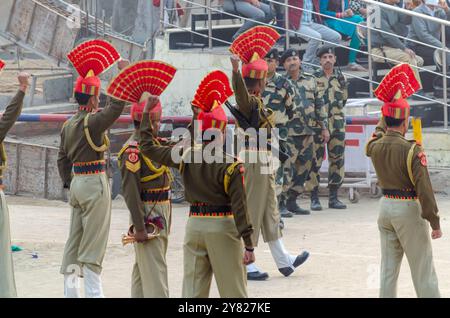 Le forze di sicurezza di frontiera sfilano durante la cerimonia di abbassamento della bandiera del confine Attari-Wagah Foto Stock