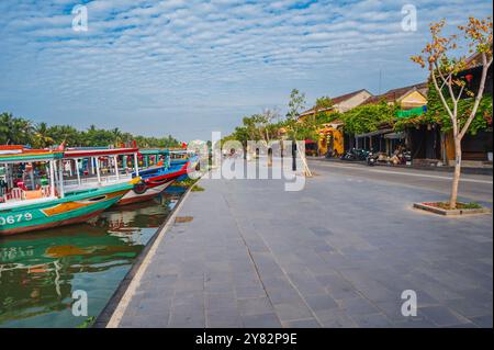 Terrapieno sul fiume Thu bon con barche nella città vecchia di Hoi An in Vietnam in estate. Hoi An, Vietnam - 12 settembre 2024 Foto Stock