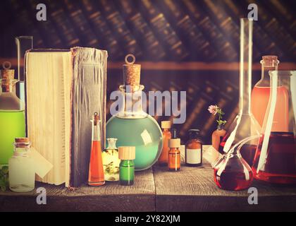 Posto di lavoro di farmacia con libri e vetreria da laboratorio vecchi, stile vintage Foto Stock