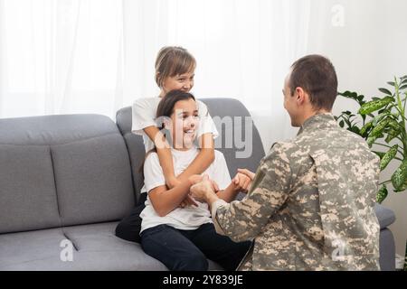 padre militare e due figlie a casa Foto Stock