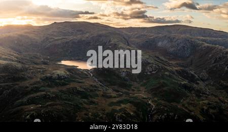 Vista aerea del lago di montagna noto come Easedale Tarn sopra il villaggio di Grasmere nel Lake District National Park che mostra la disposizione geografica di un Foto Stock