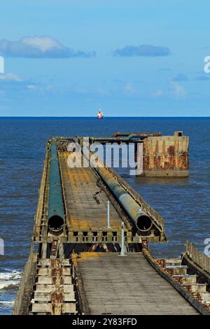 Guardando verso il molo di Steetly come una nave si trova all'ancora al largo della costa vicino a Hartlepool. Il molo è una reliquia lunga 2000 metri proveniente dall'industria chimica locale Foto Stock