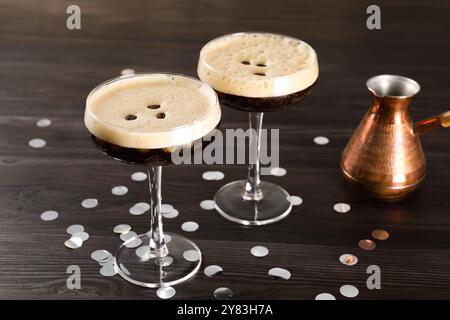 Cocktail di caffè freschi in bicchieri, coriandoli e cezve su un tavolo di legno Foto Stock