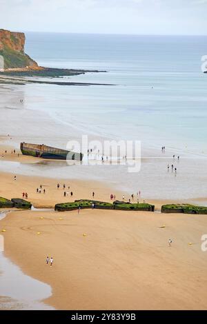 Visitatori che esplorano i resti di Mulberry Harbour, Arromanches Beach, Normandia Francia Foto Stock