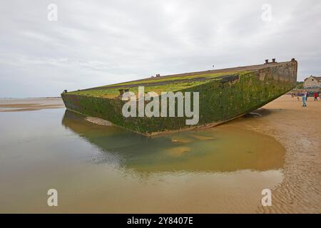 Visitatori che esplorano i resti di Mulberry Harbour, Arromanches Beach, Normandia Francia Foto Stock