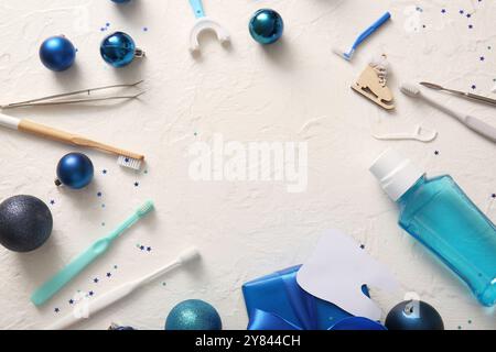 Cornice realizzata con diversi strumenti dentisti e decorazioni natalizie su sfondo chiaro Foto Stock
