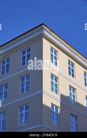 Un edificio d'angolo rosa con molte finestre che si affacciano su un cielo azzurro, Bergen, Vestland, Norvegia, Europa Foto Stock