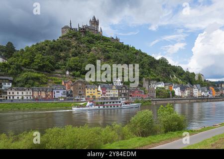 Castello storico su una collina boscosa con una nave di passaggio sul fiume e edifici colorati lungo la riva, Reichsburg, Cochem, Cochem-Zell, Mosella, R Foto Stock