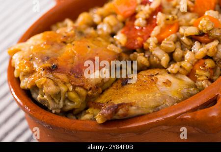 Cosce di pollo con porridge di orzo in pentola di argilla Foto Stock