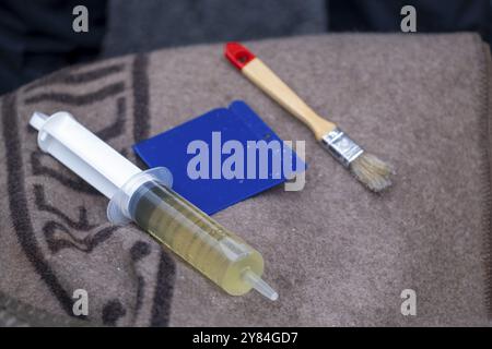 Germania, Berlino, 28 ottobre 2023, per rimuovere la supercolla: Siringa dell'olio, spatola, spazzola, Europa Foto Stock