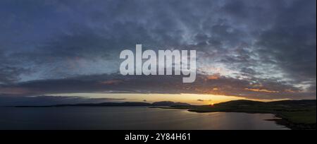 Tramonto con banda nuvolosa sulla costa di Scapa Flow con vista sull'isola di Hoy, drone shot, Orphir, Orkney, Scozia, gran Bretagna Foto Stock