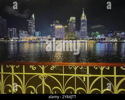 Skyline Saigon, grattacieli illuminati al centro con la Bitexo Tower sul fiume Song Sai Gon di notte, ho chi Minh City, Vietnam, Asia Foto Stock