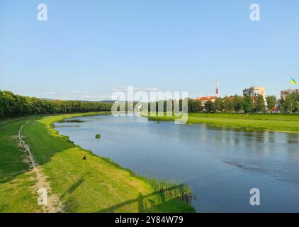 Vista panoramica estiva della città di Uzhhorod e del fiume Uzh, della Transcarpazia, Ucraina. Paesaggio tranquillo i con fiume tranquillo e campi verdi Foto Stock