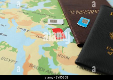 Schede SIM e passaporti sulla mappa del mondo, primo piano Foto Stock