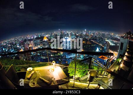 BANGKOK, Thailandia: Lo scintillante skyline notturno di Bangkok si estende sotto, visto dal ristorante Vertigo sul tetto in cima al Banyan Tree H. Foto Stock