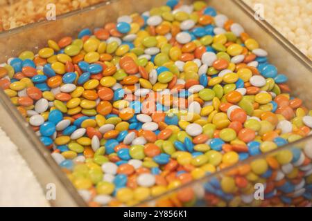 Un variegato e colorato assortimento di cioccolatini ricoperti di caramelle splendidamente disposti in un display Foto Stock