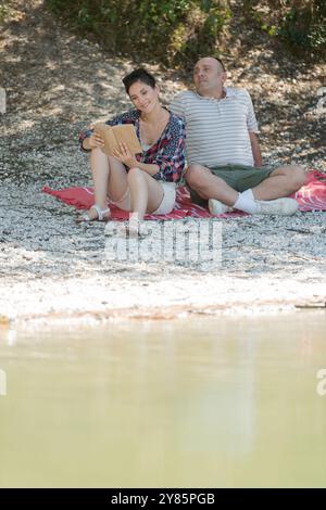 coppia rilassante sul molo accanto al lago Foto Stock