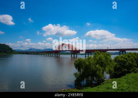Vista panoramica del Ponte Banghwa sul fiume Han a Seoul, con il suo arco rosso brillante contro un cielo limpido. Foto Stock
