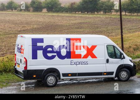 Un furgone FedEx parcheggiato in una corsia di campagna del Norfolk sotto la pioggia. Foto Stock