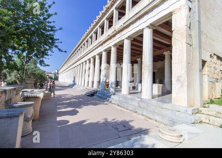 Una bella donna in piedi alle colonne del Museo dell'Antica Agorà. STOA di Attalos: Maestosa architettura ellenistica nell'Agorà di A. Foto Stock