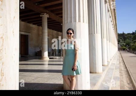 Una bella donna in piedi alle colonne del Museo dell'Antica Agorà. STOA di Attalos: Maestosa architettura ellenistica nell'Agorà di A. Foto Stock