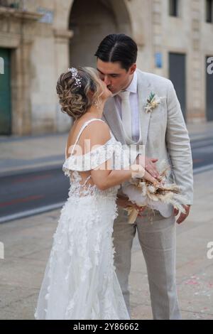 Sposi novelli che si baciano per strada dopo la cerimonia, Alicante, Spagna Foto Stock