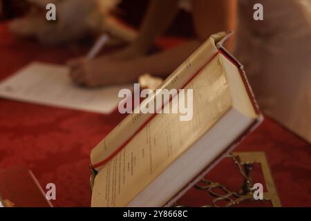 Libro di nozze in primo piano e firma di un documento con persona irriconoscibile, Alicante, Spagna Foto Stock