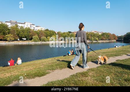 Giovane donna che cammina con il cane, Urbanhafen, Landwehrkanal, Kreuzberg, Berlino, canale del fiume Sprea in Germania Foto Stock