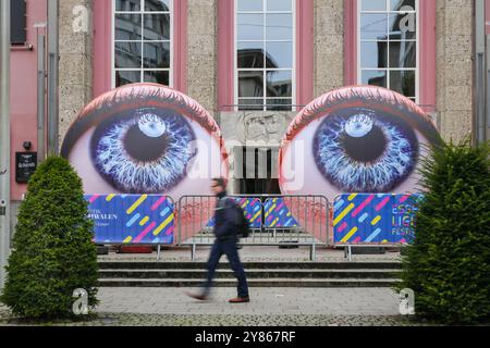 Essen, NRW, Germania. 2 ottobre 2024. I visitatori interagiscono con l'installazione "Oculus" degli artisti H:e:M (Italia) fuori dal Teatro Grillo. Due sfere giganti brillano a forma di due occhi che guardano verso il cielo. Serata di apertura dell'annuale Essen Light Festival con 16 installazioni di luci su larga scala in tutta la città. Il festival è gratuito e si svolge ogni sera dal tramonto alle 23:00, dal 2 al 13 ottobre 2024. Crediti: Imageplotter/Alamy Live News Foto Stock